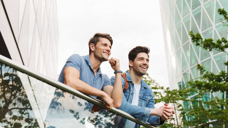 Two happy friends standing in the balcony