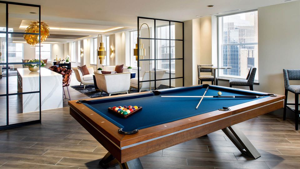 a pool table in a living room with a couch and chairs at The  First