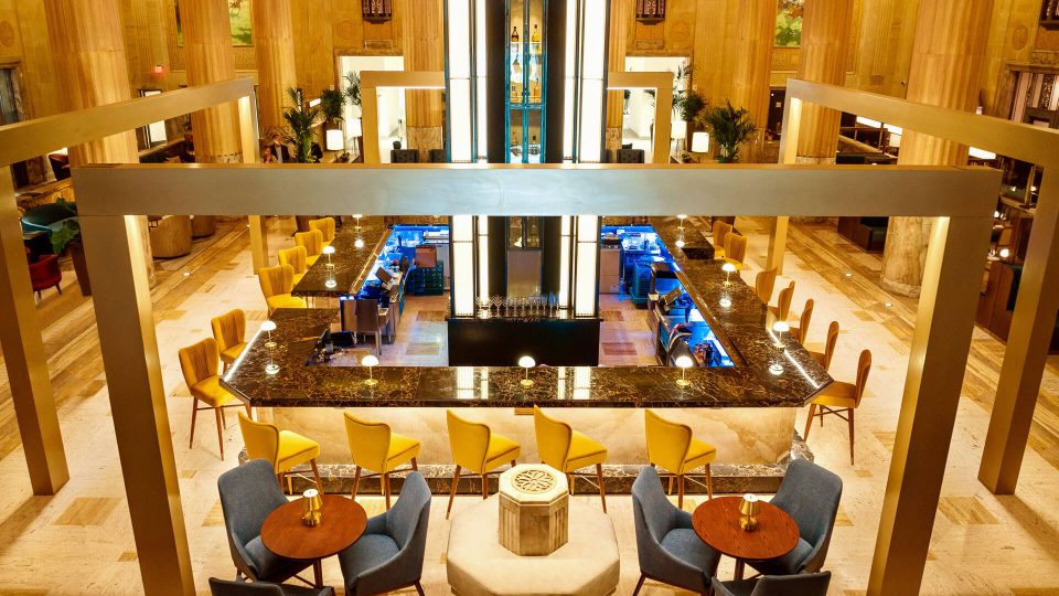 the lobby of a hotel with a bar and chairs at The  First