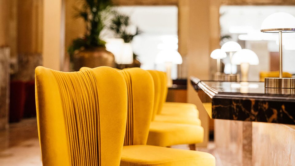 yellow chairs in a hotel lobby with a lamp at The  First