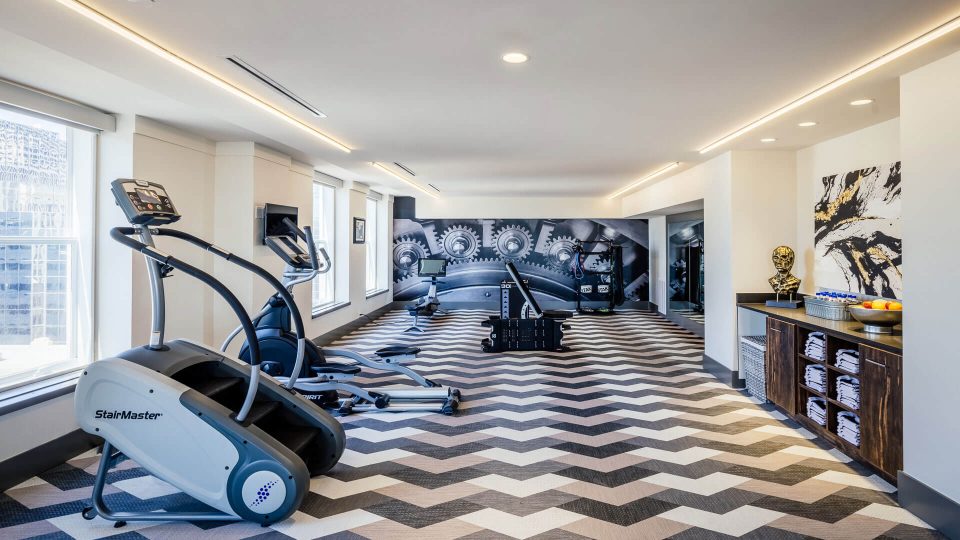 a gym room with treads and exercise equipment at The  First