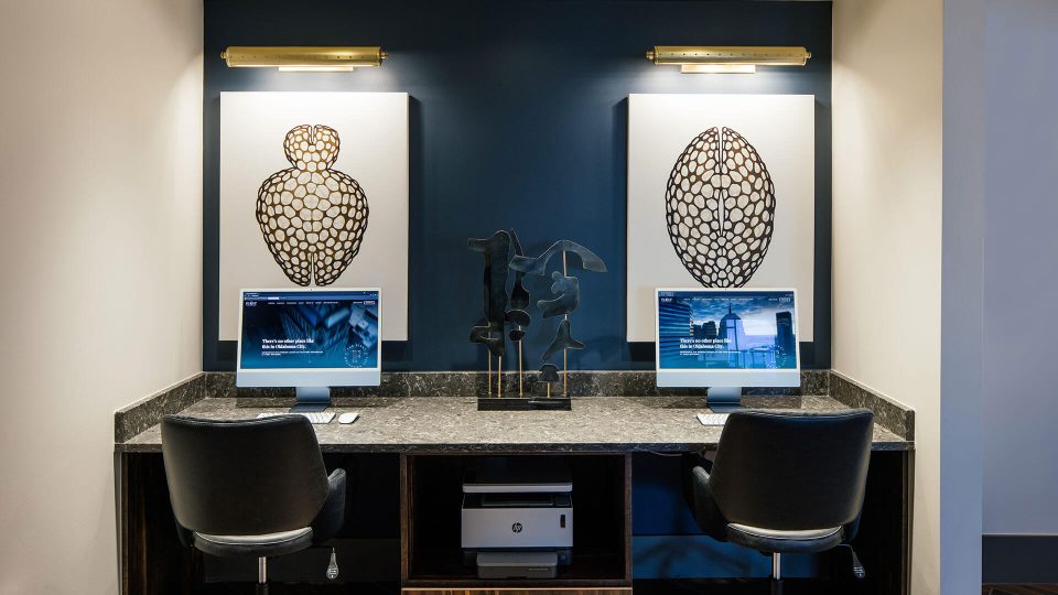 a home office with two computers and two paintings at The  First