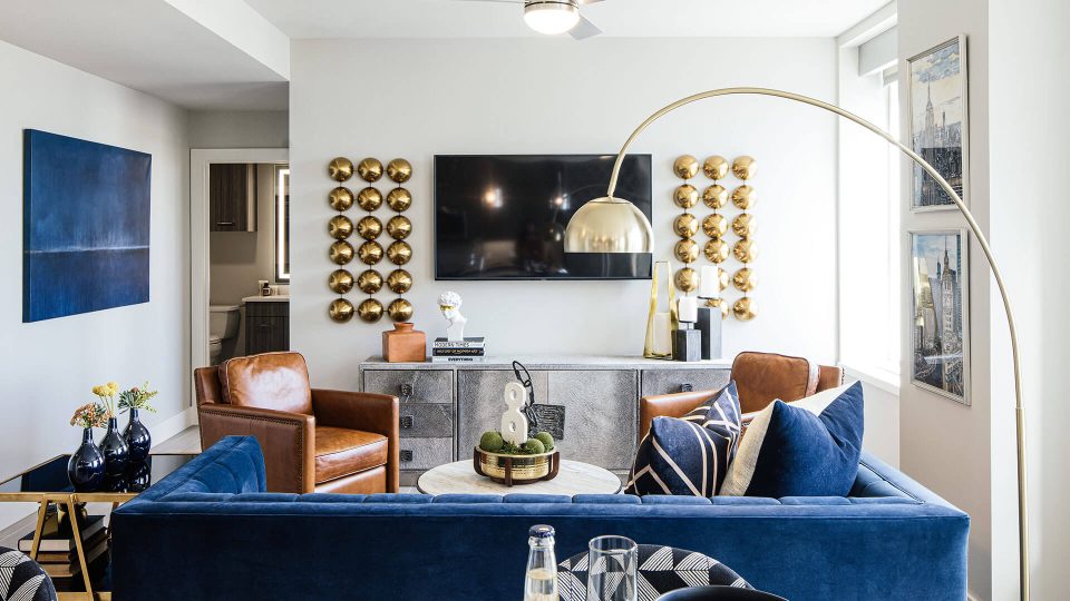 a living room with blue couches and a large flat screen tv at The  First