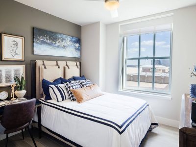 a bedroom with a bed, desk, and pictures on the wall at The  First