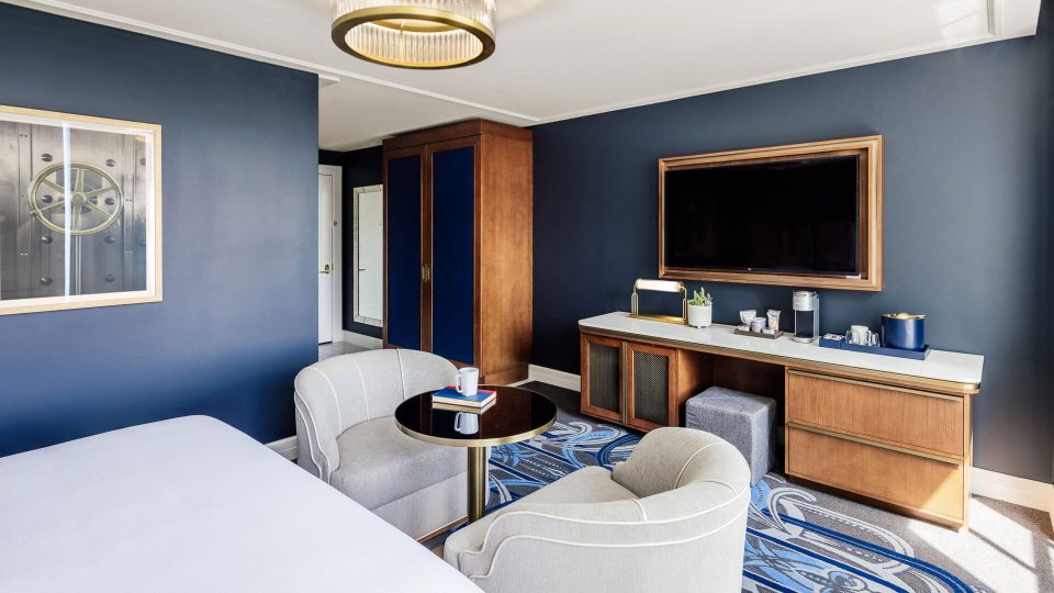 a hotel room with blue walls and a television at The  First