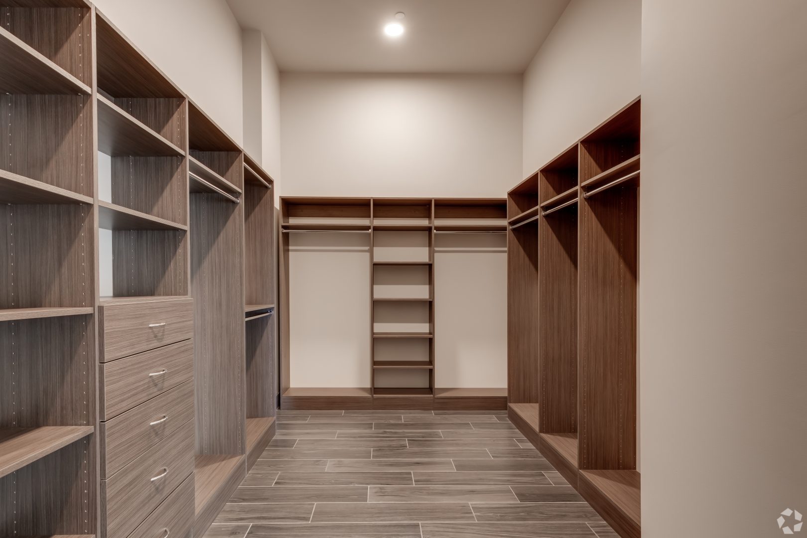 a walk in closet with shelves and cabinets at The  First