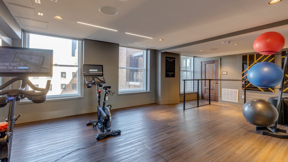 a gym room with exercise equipment and a television at The  First