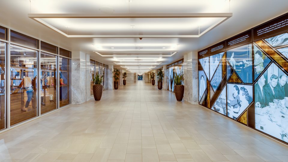 a long hallway with glass walls and large windows at The  First
